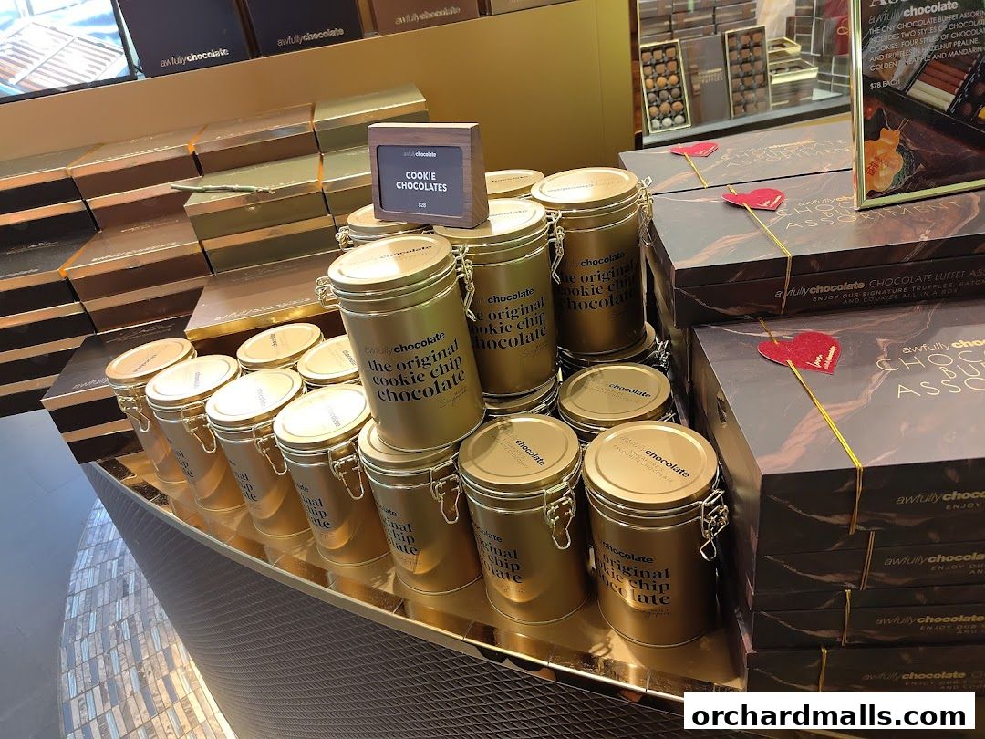 A display of Awfully Chocolate cookie chip chocolate tins and assorted chocolate boxes.