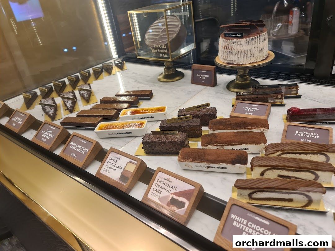 A display case filled with various chocolate cakes and desserts from Awfully Chocolate.