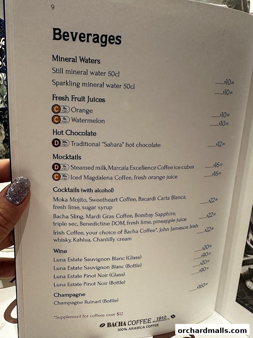 A menu page from Bacha Coffee featuring a variety of beverages including mineral waters, juices, hot chocolate, mocktails, cocktails, wine, and champagne.