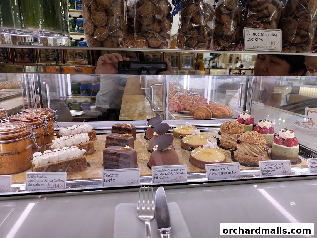 A display case filled with various pastries, cakes, and cookies at Bacha Coffee.