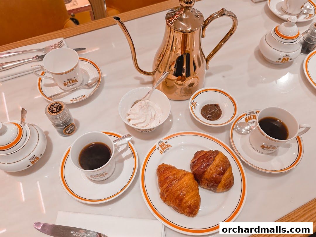 A table setting with coffee, croissants, and whipped cream from Bacha Coffee.