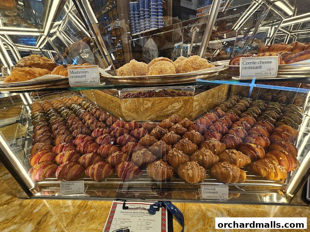 A display case filled with a variety of gourmet croissants at Bacha Coffee.