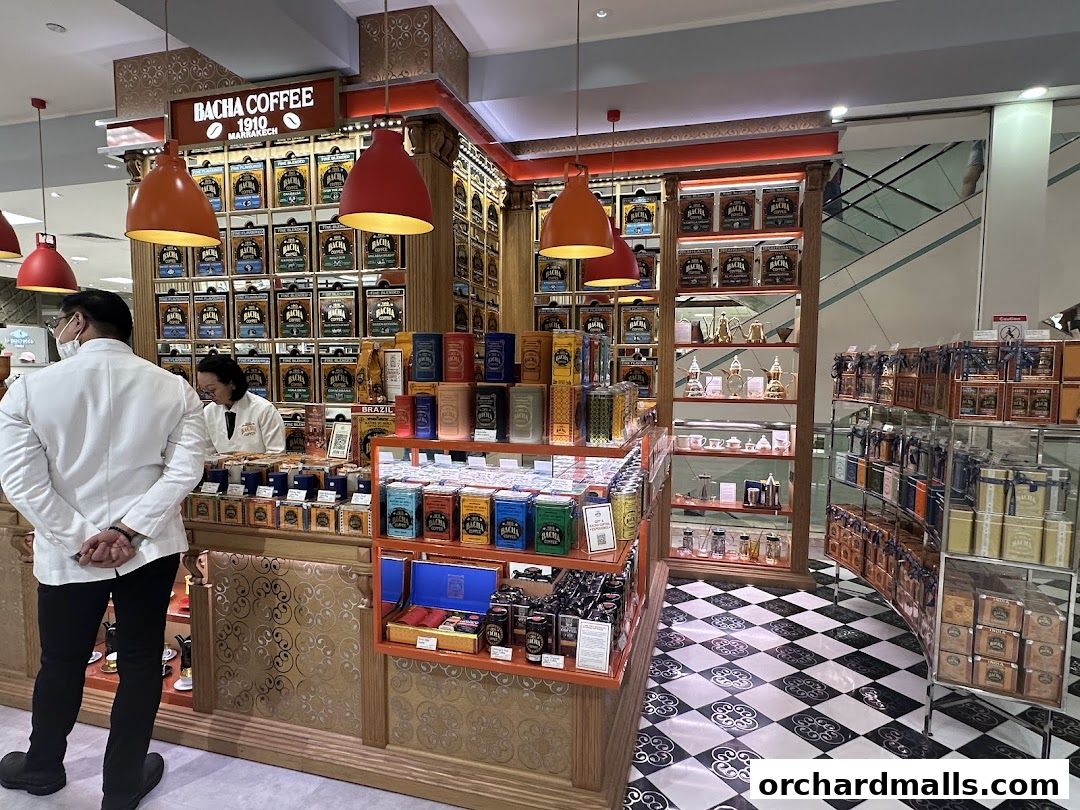 Bacha Coffee shop interior with staff and displays of coffee tins and merchandise.