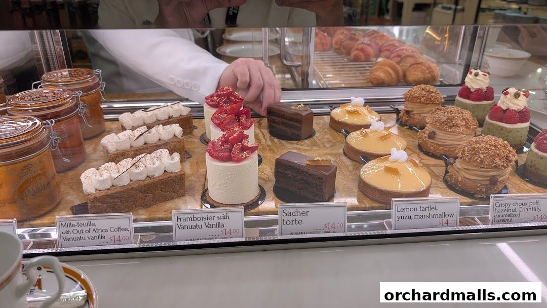 A display case filled with various gourmet pastries and desserts at Bacha Coffee.