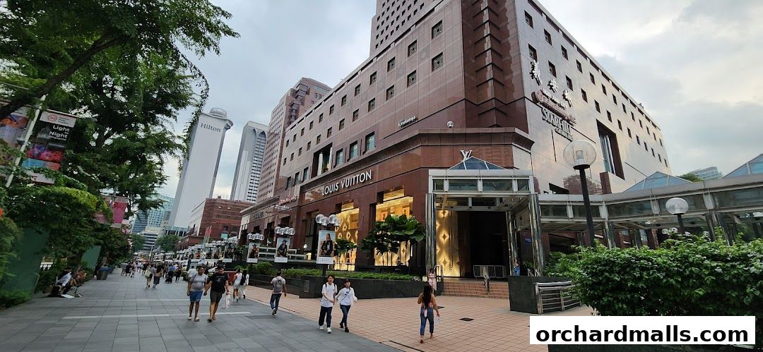 Exterior view of a Louis Vuitton store and surrounding buildings on a pedestrian walkway.