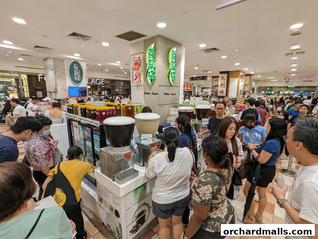 A busy beverage shop with a long queue of customers ordering drinks.