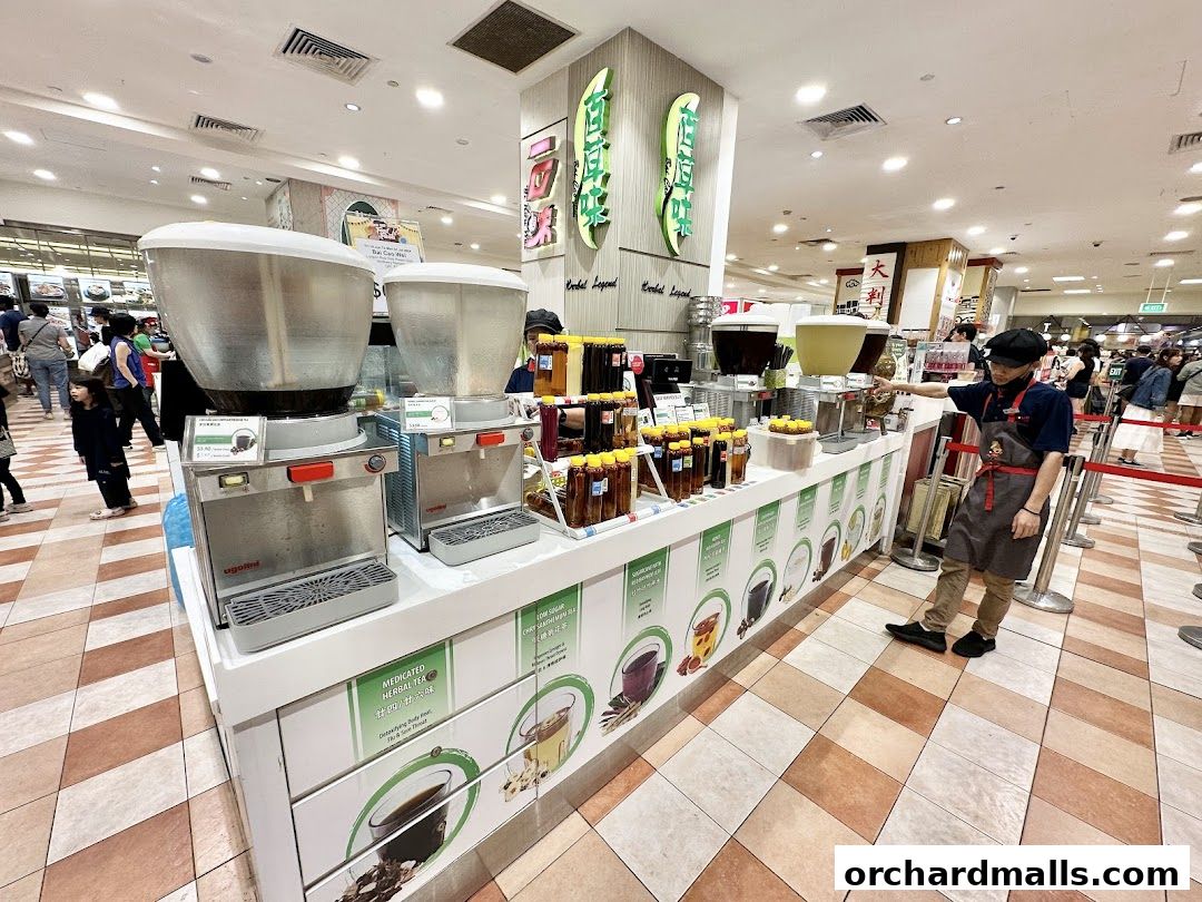 A beverage stall with large dispensers and bottled drinks, staffed by an employee.