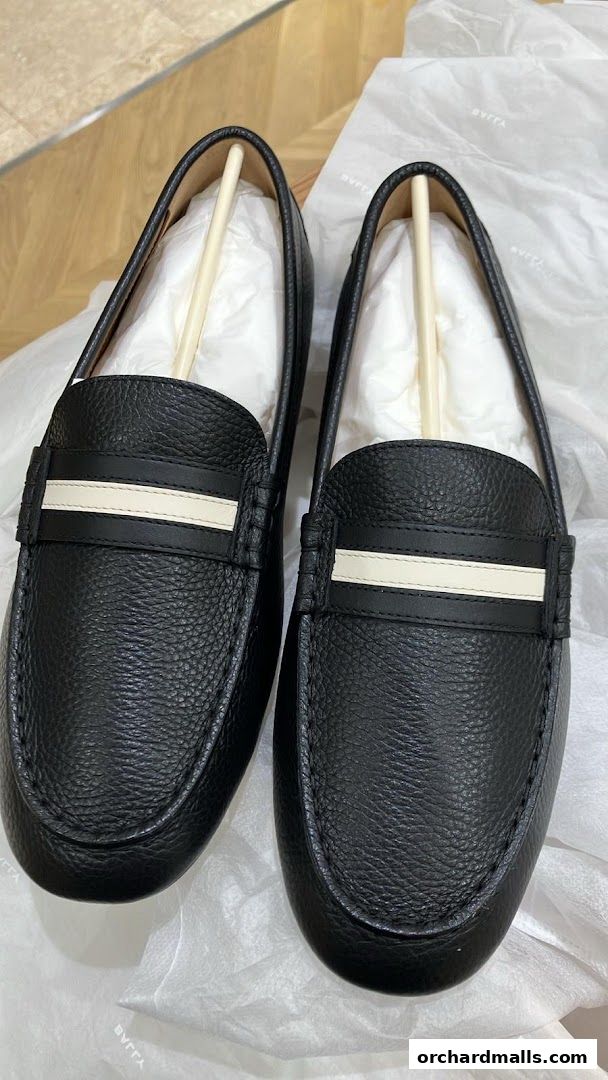 A pair of black leather Bally loafers with white stripe detail, presented in packaging.