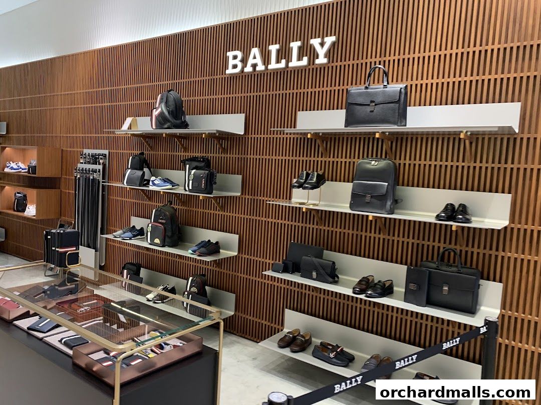 Interior view of a Bally store showcasing luxury bags, shoes, and accessories on wooden shelves.