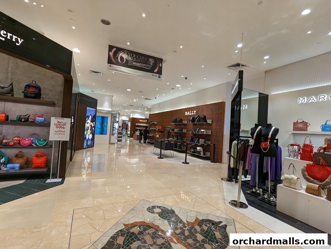 Interior view of a luxury handbag store showcasing various bags and a sale banner.