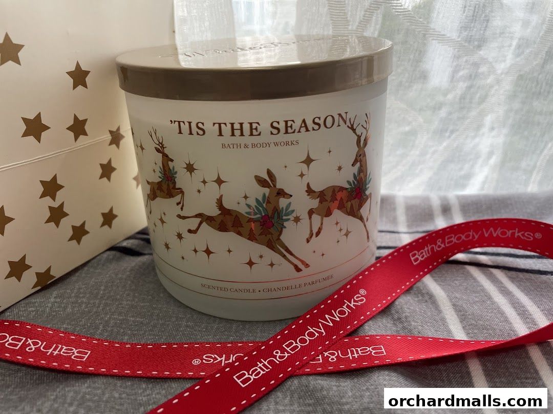 A Bath & Body Works scented candle with a festive holiday design and red ribbon.