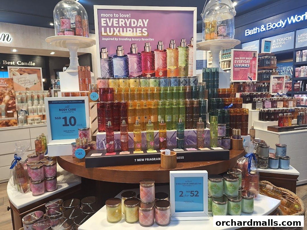 A display of Bath & Body Works products, featuring body care and candles, with promotional signage.