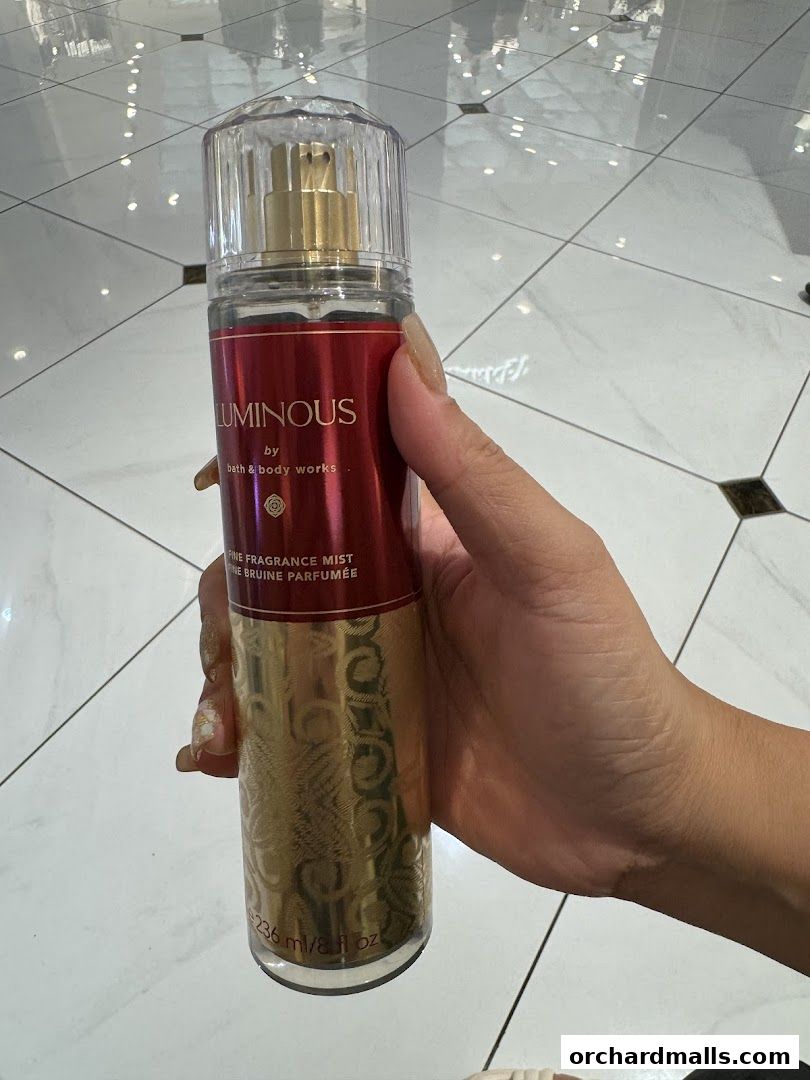 A hand holds a Bath & Body Works Luminous Fine Fragrance Mist.