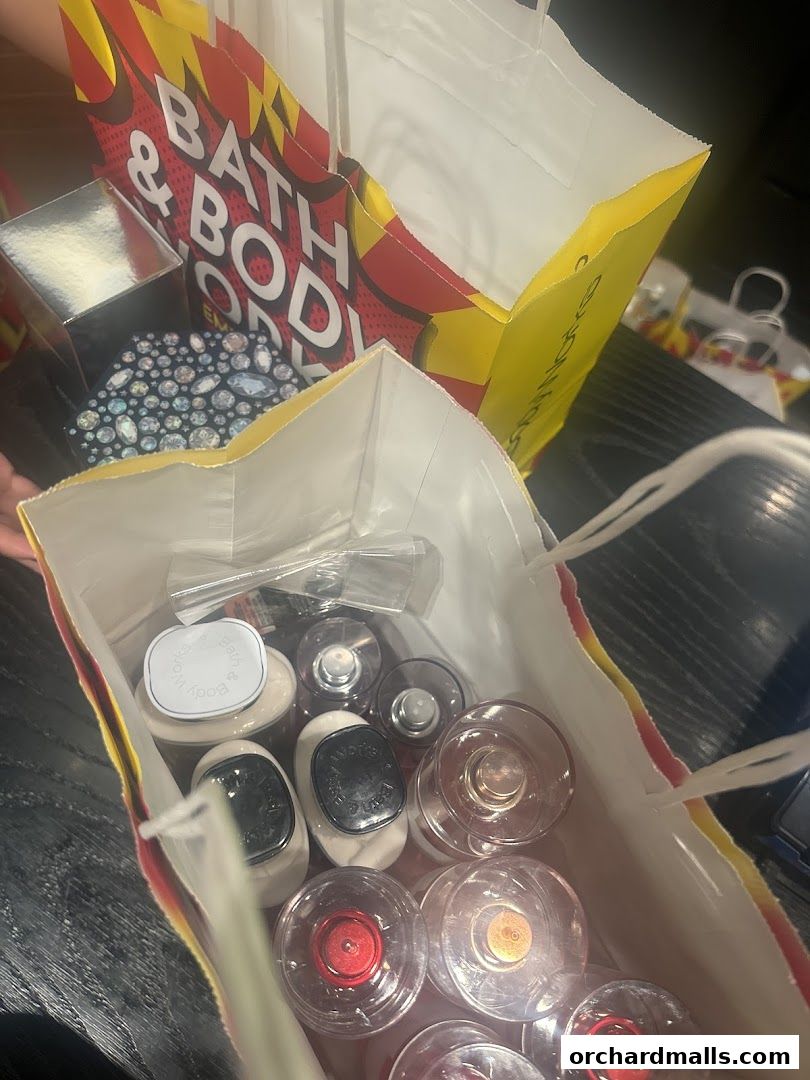 Shopping bags filled with Bath & Body Works products, including lotions and fragrances.