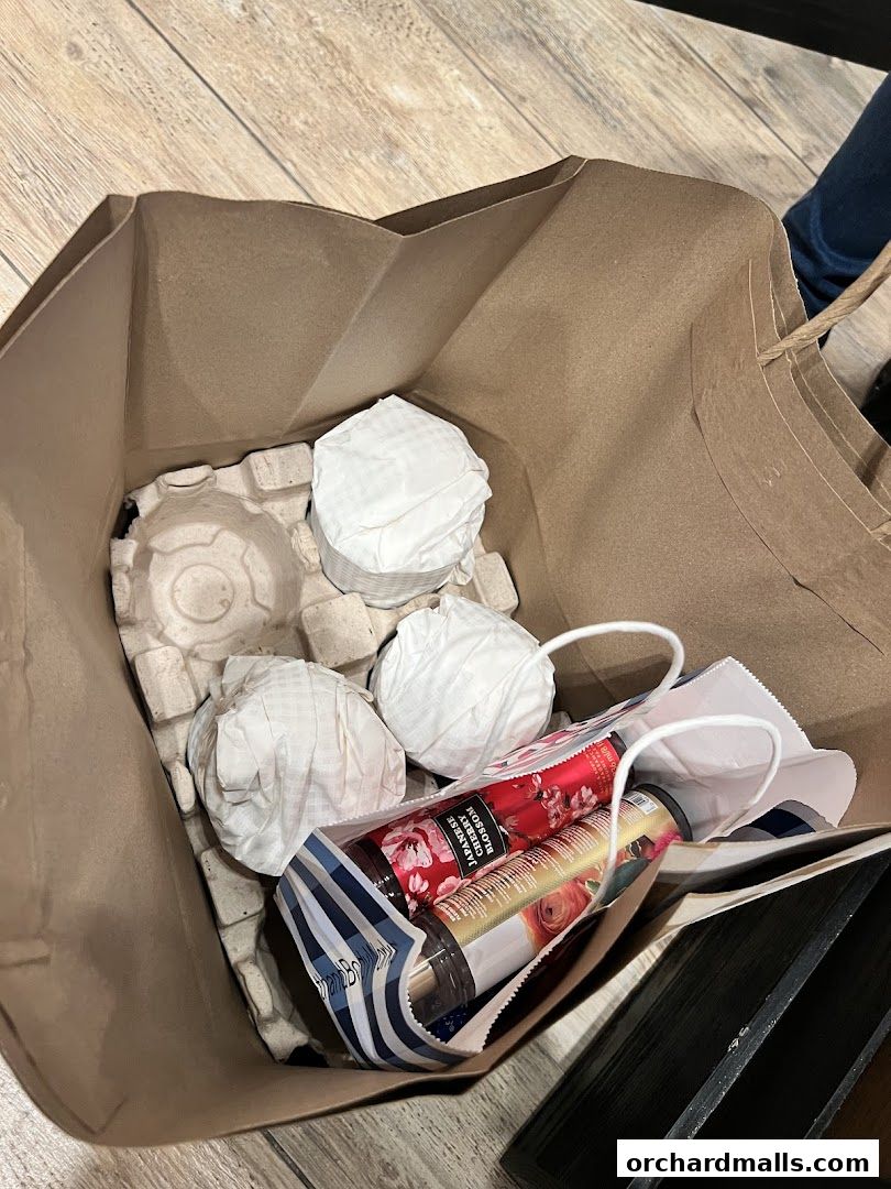 A shopping bag filled with Bath & Body Works products, including lotions and wrapped items.