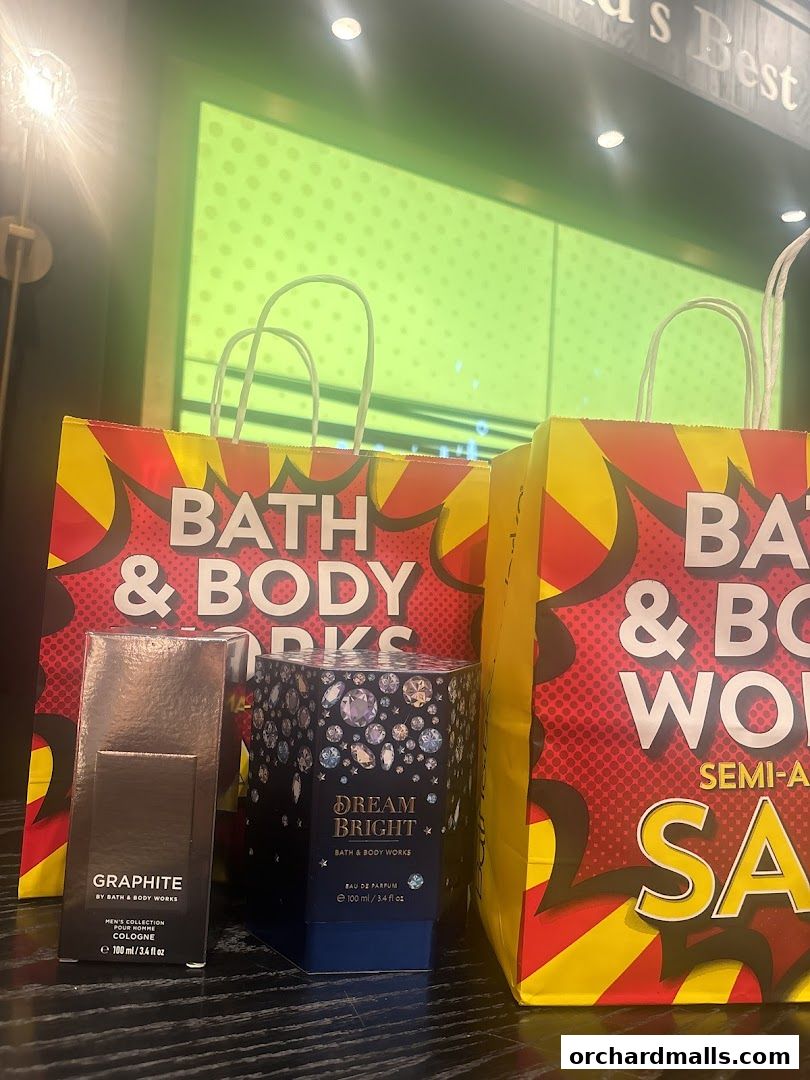 Bath & Body Works shopping bags and two perfume boxes on display.