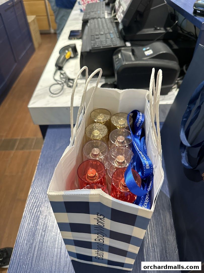 A shopping bag filled with Bath & Body Works perfumes and other items.