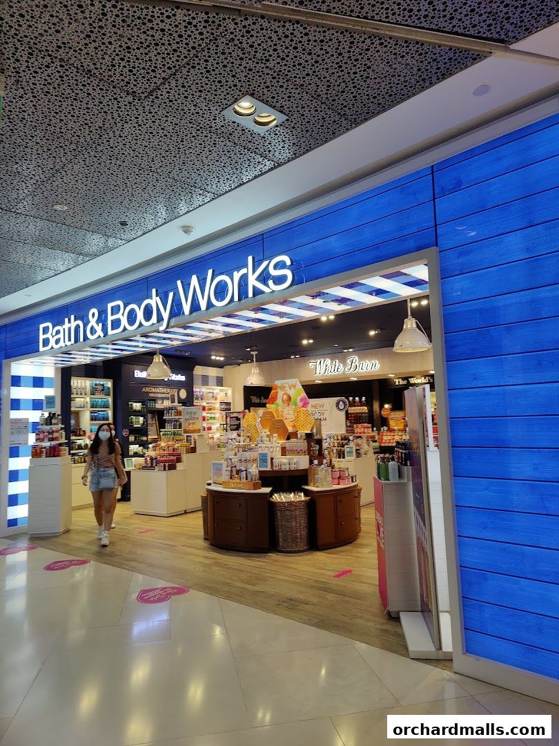 Exterior view of Bath & Body Works shop with blue wooden facade and interior displays.
