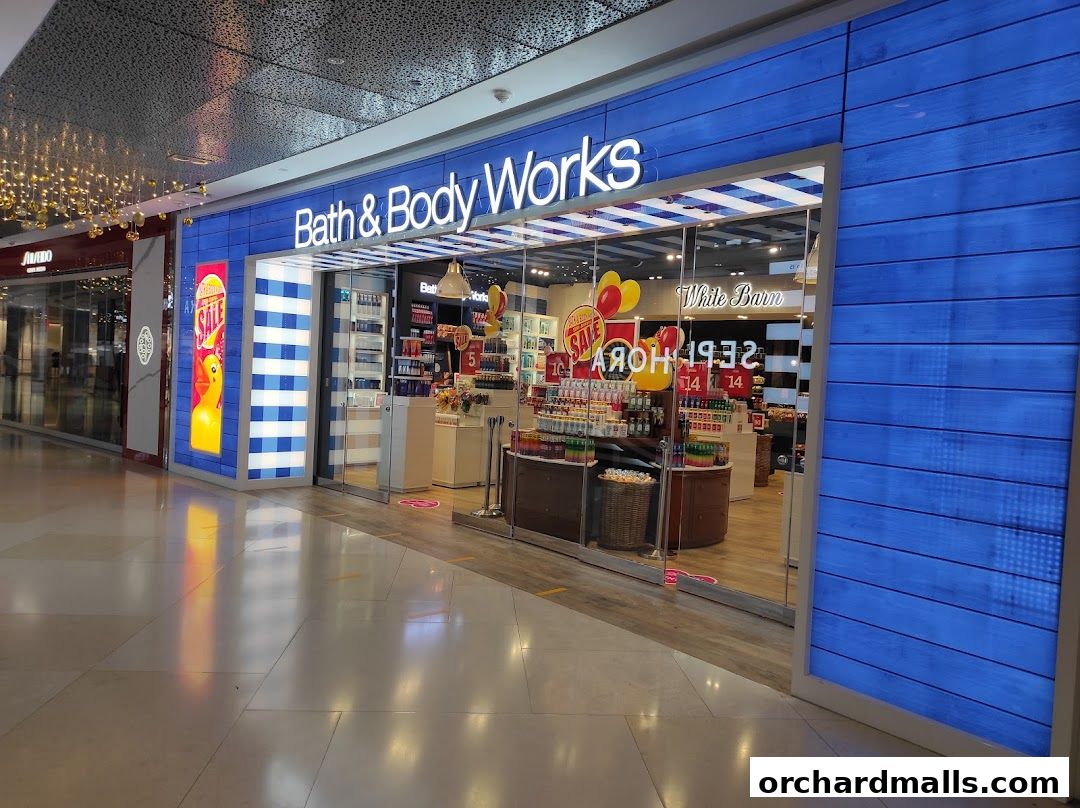 Bath & Body Works shop front with blue wooden paneling and a display of sale items.