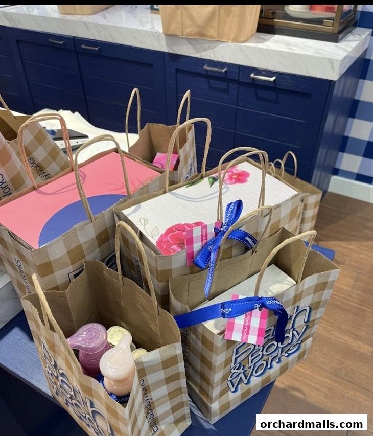 Brown paper shopping bags with Bath & Body Works branding and colorful contents.