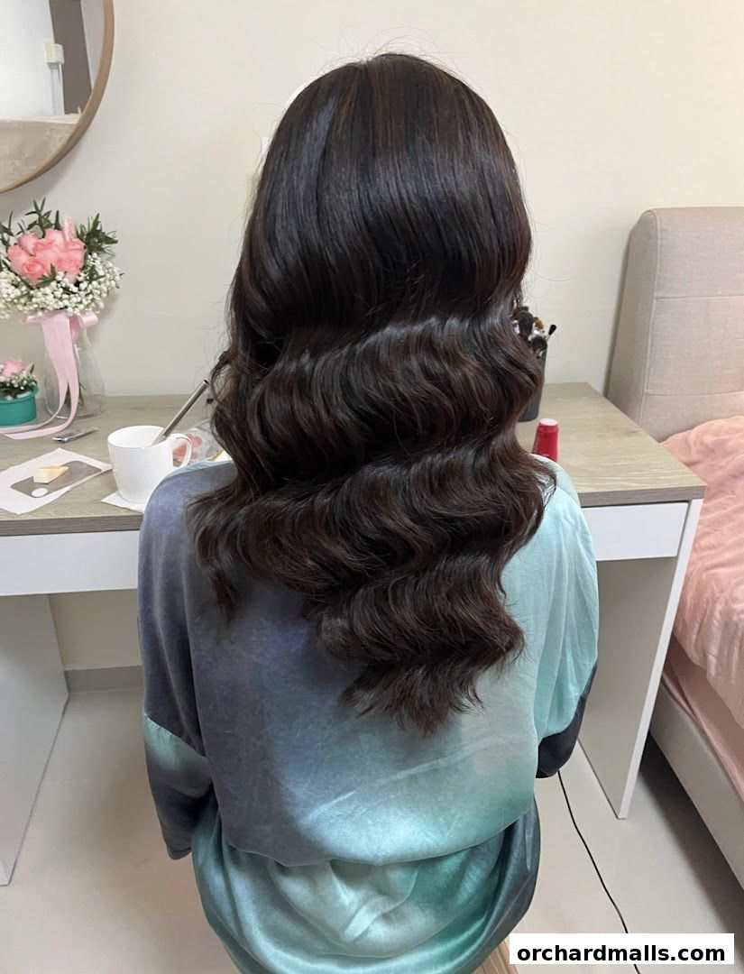 A person with long, dark, wavy hair styled in a salon.