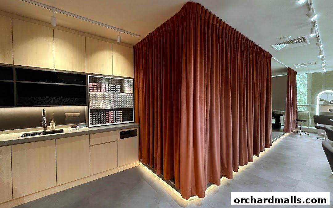 Interior of a modern salon with a sink area, product display, and draped curtains.
