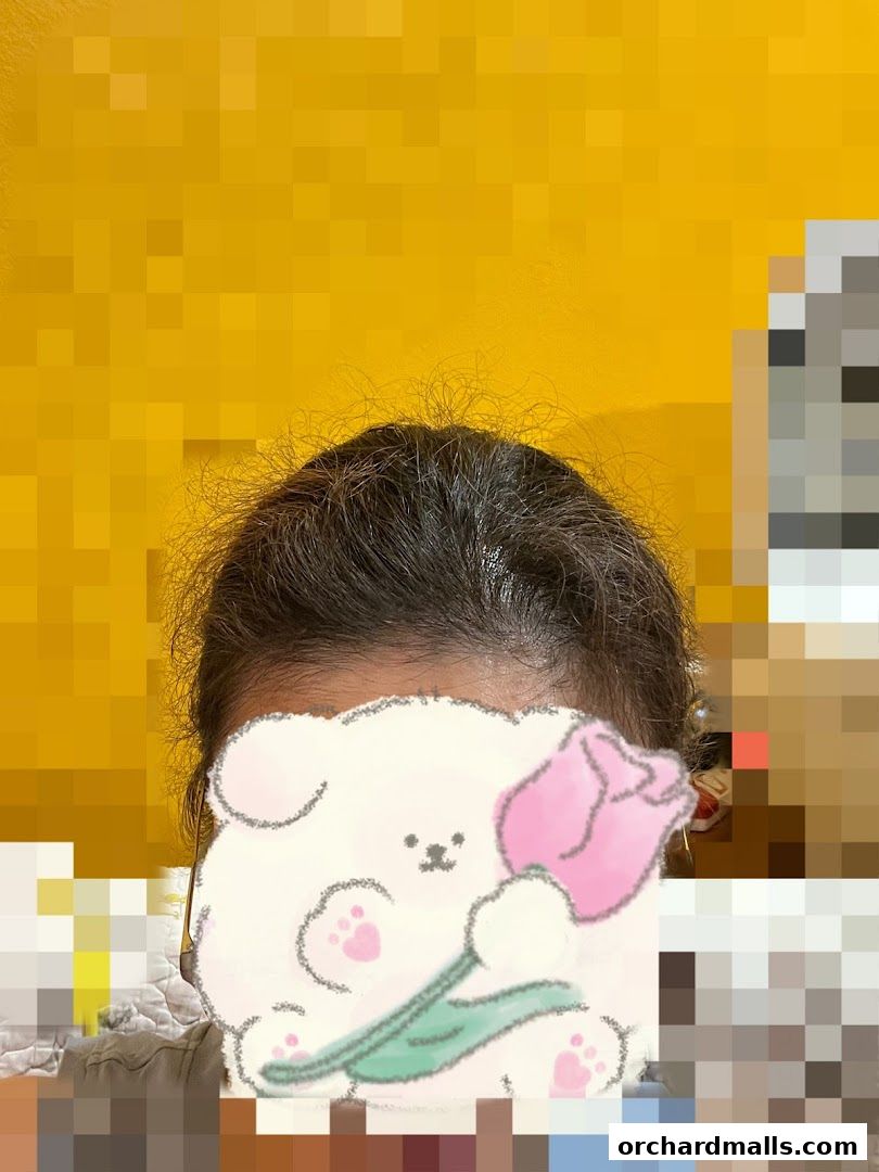 A person's head with a drawing of a fluffy dog holding a pink tulip.