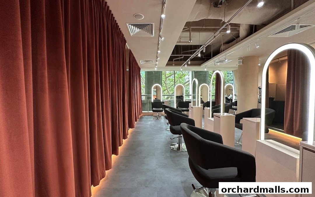 Interior view of a modern hair salon with styling chairs and illuminated mirrors.