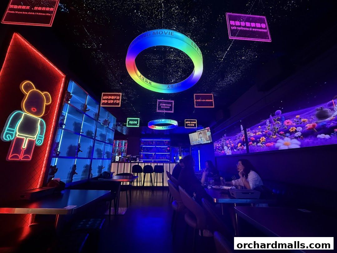 Interior of a neon-lit bar with a large ring light and digital art display.
