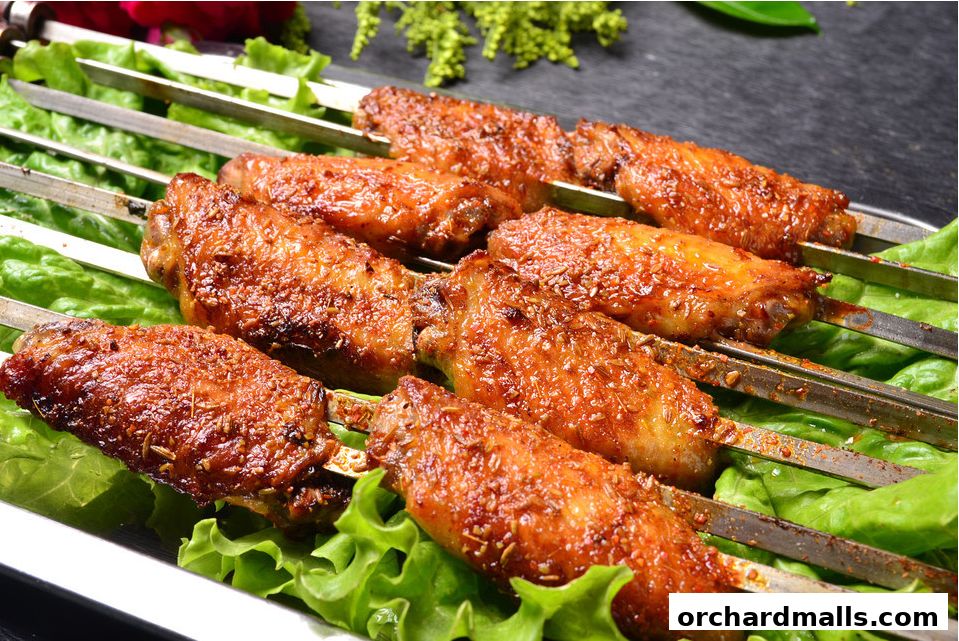 Close-up of grilled chicken wings on skewers, served on a bed of lettuce.