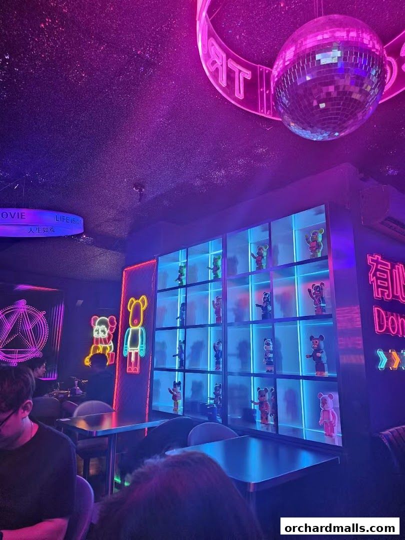 Interior of a neon-lit shop with display shelves filled with bear figurines and a disco ball.