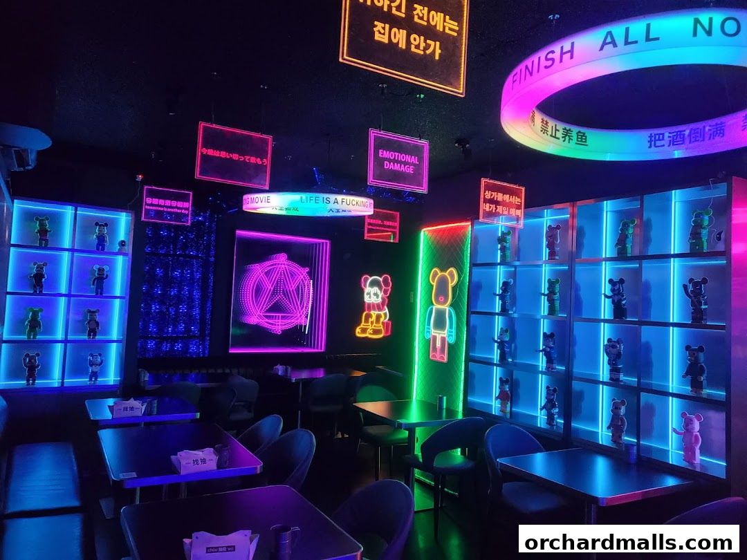 Interior of a neon-lit bar with shelves displaying bear figurines and various neon signs.