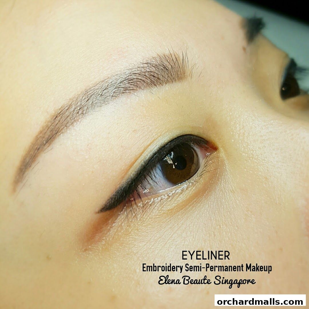 Close-up of a woman's eye with perfectly applied eyeliner and semi-permanent makeup.
