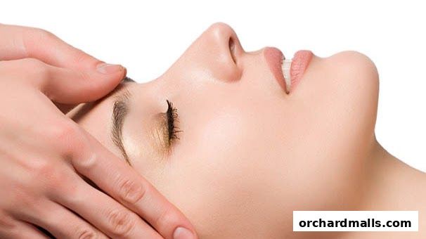 Close-up of a person receiving a facial massage with hands gently touching the face.