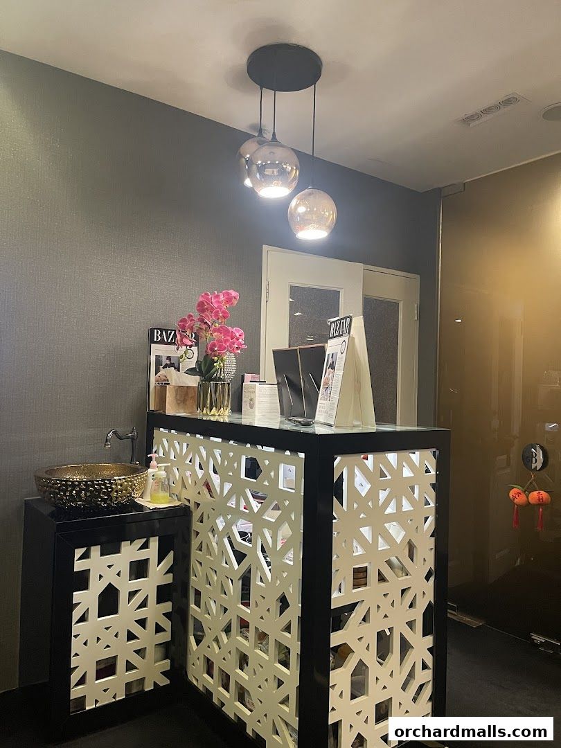 Reception desk with decorative screen, sink, and floral arrangement.