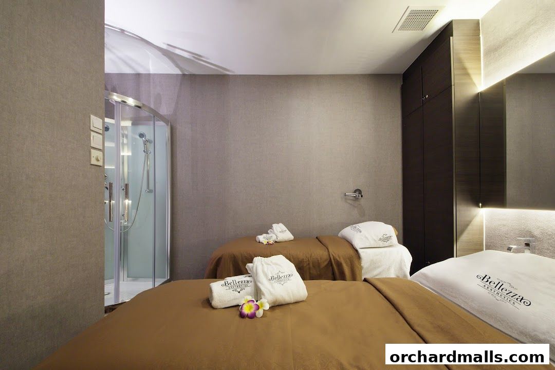 Interior of a spa room with two massage beds, a shower, and amenities.