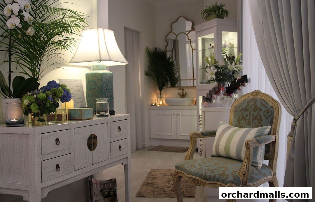 Interior of a well-lit salon with decorative furniture, plants, and display shelves.