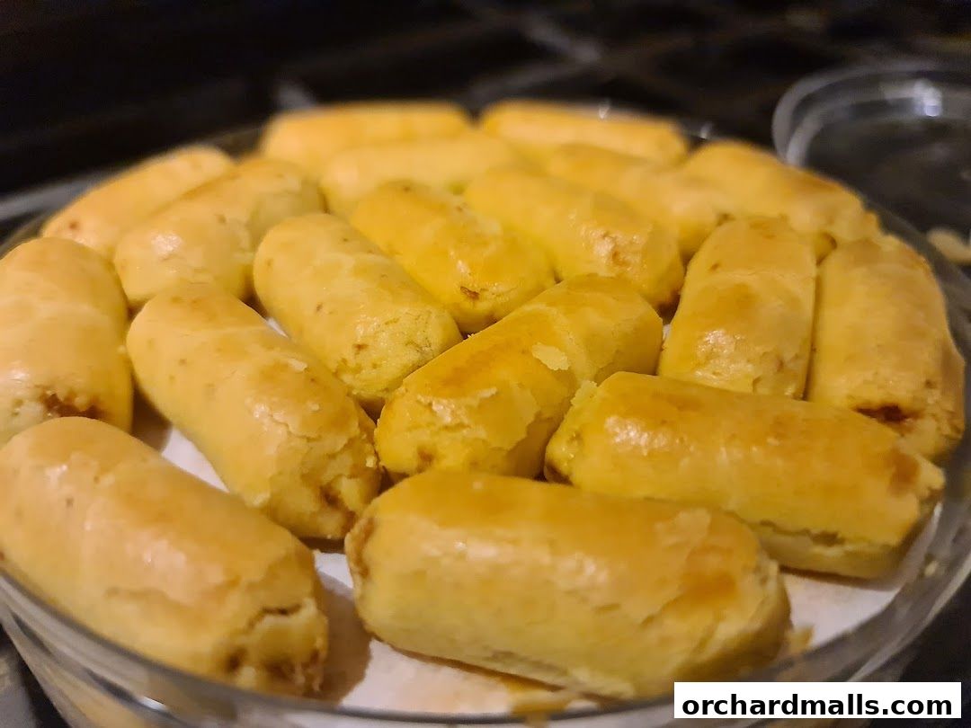 A close-up shot of golden-brown, cylindrical pastries filled with a sweet filling.