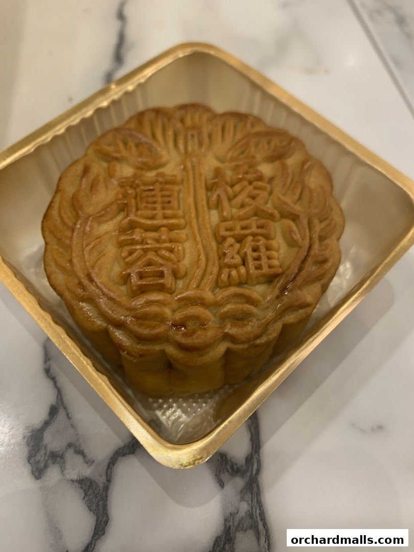 A close-up shot of a traditional mooncake with intricate Chinese characters embossed on its surface.
