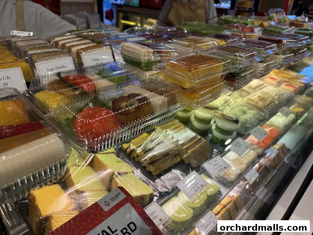 A display case filled with various individually packaged cakes and desserts.