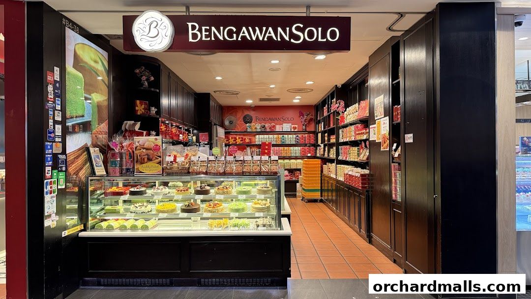 A well-lit bakery shop displaying a variety of cakes and pastries in a display case.