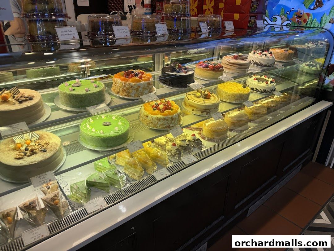 A display case filled with a variety of beautifully decorated cakes and pastries.