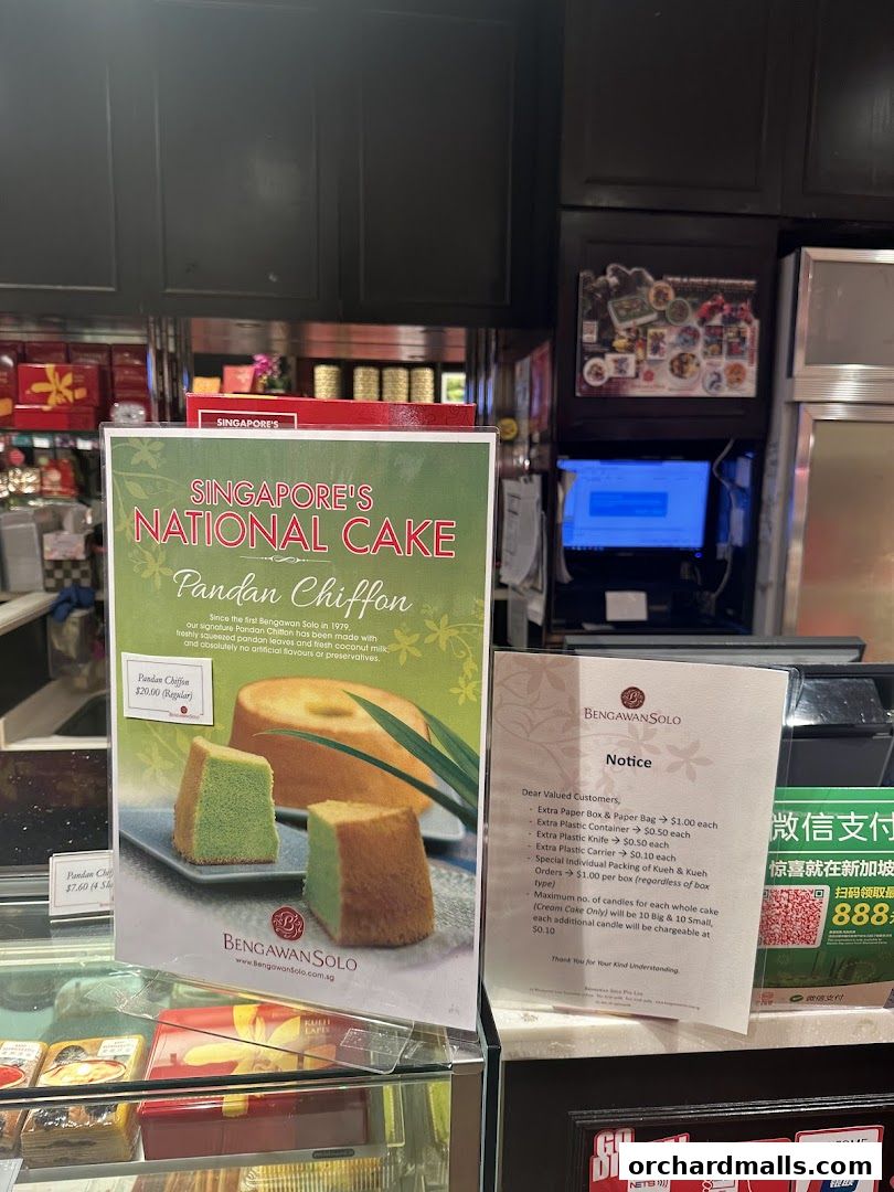 A display of Pandan Chiffon cake at Bengawan Solo, with a promotional poster and a notice about packaging charges.