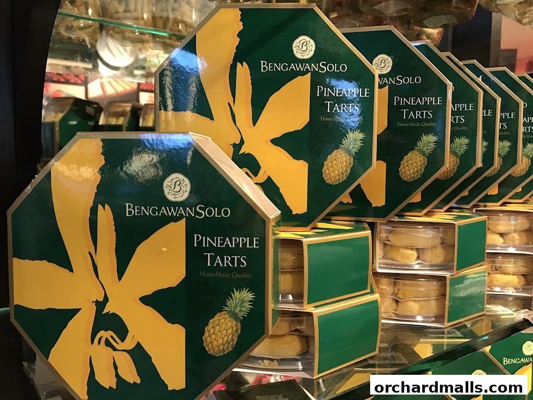 A display of Bengawan Solo pineapple tarts in distinctive green and gold packaging.