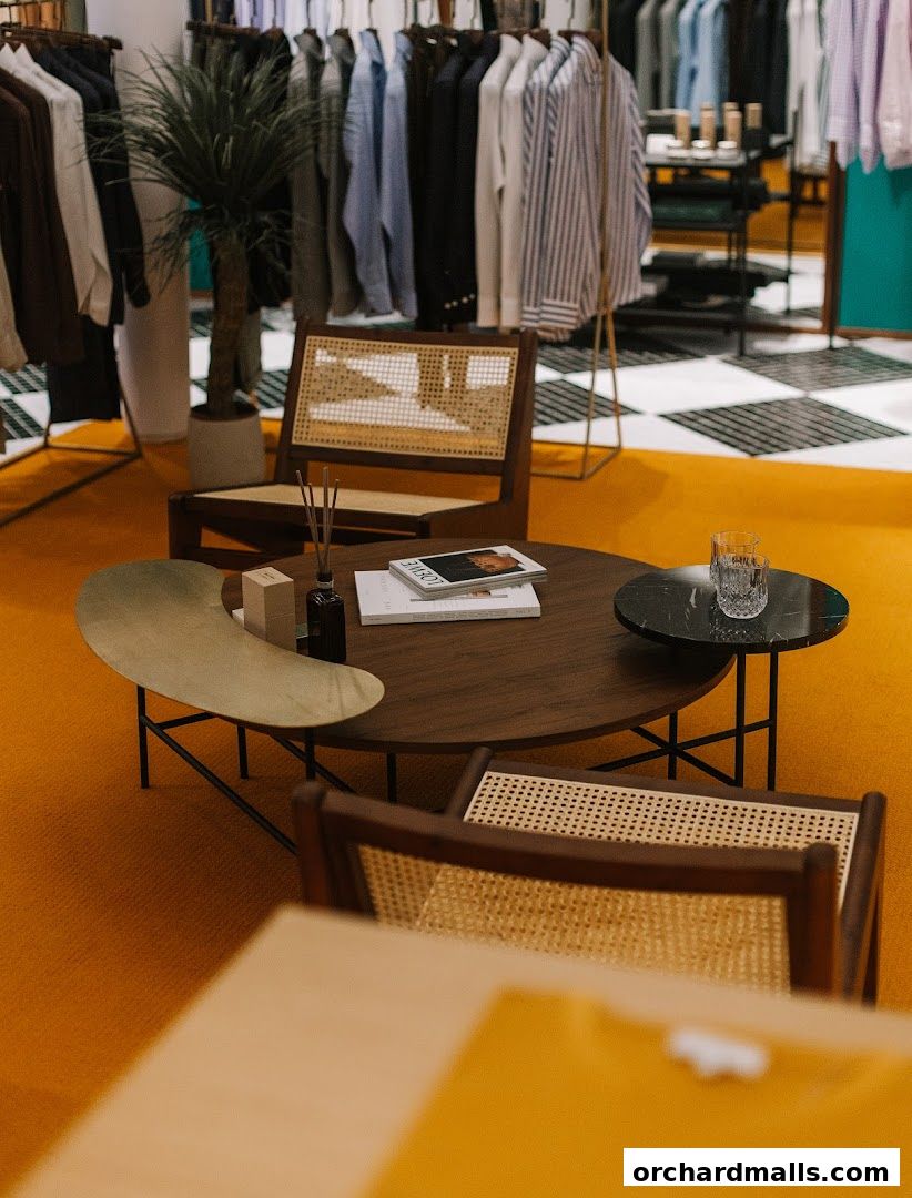 Interior of a stylish clothing store with racks of shirts and a seating area.