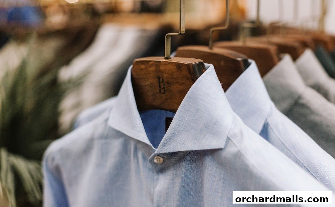 Close-up of light blue dress shirts on wooden hangers with the 'BB' logo.