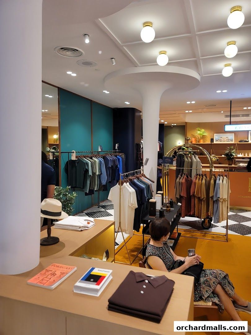 Interior of a stylish clothing store with apparel displayed on racks and shelves.