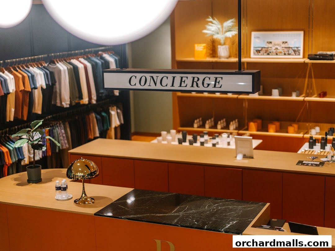 Interior of a modern retail store with clothing racks and a concierge desk.