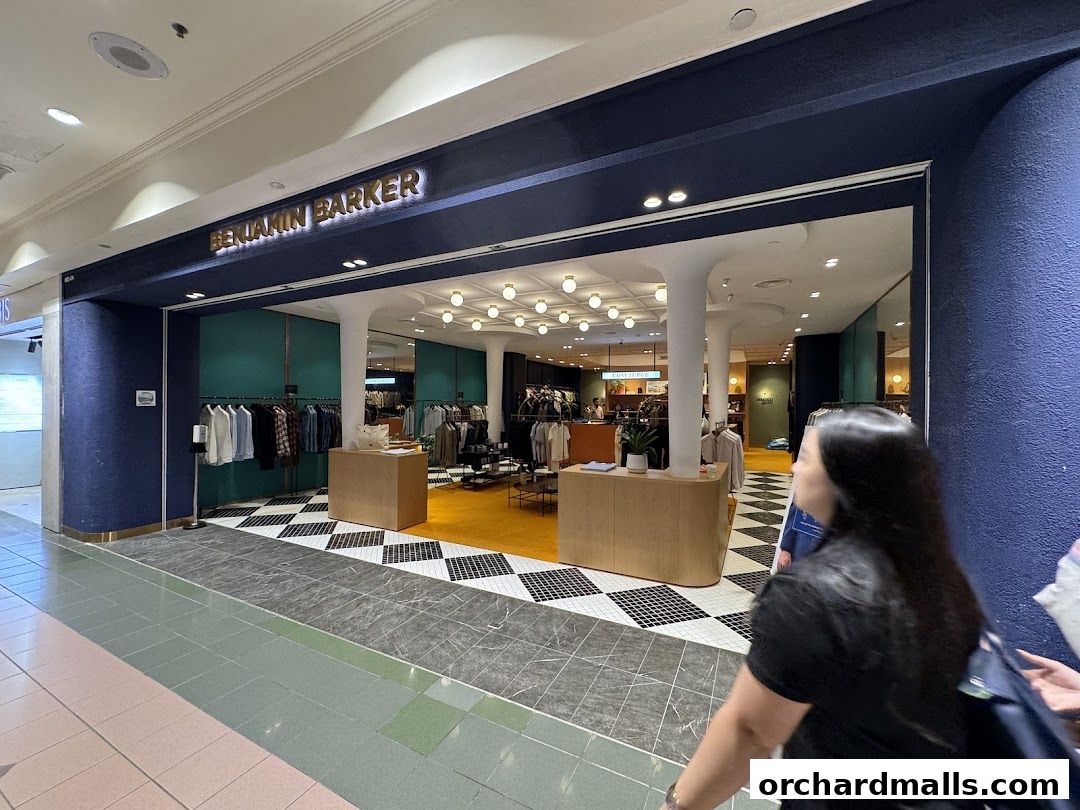 The entrance of Benjamin Barker, a clothing store, with apparel displayed inside.