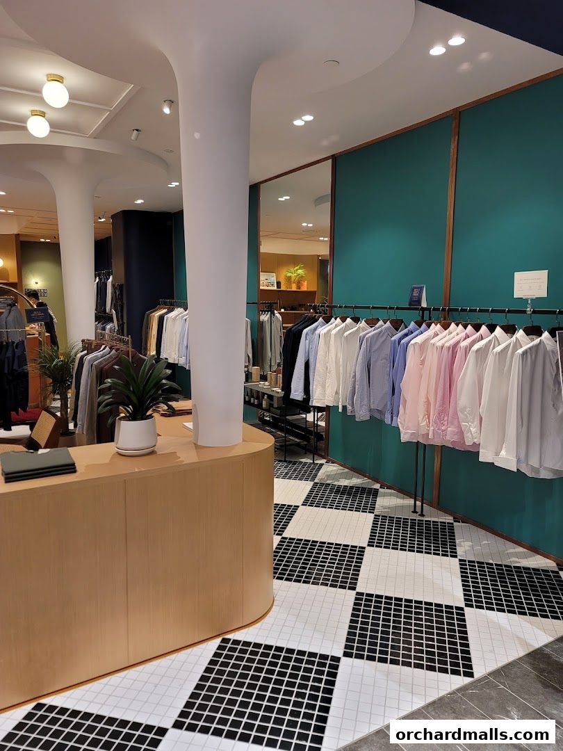 Interior view of Benjamin Barker clothing store with shirts on display and a checkout counter.